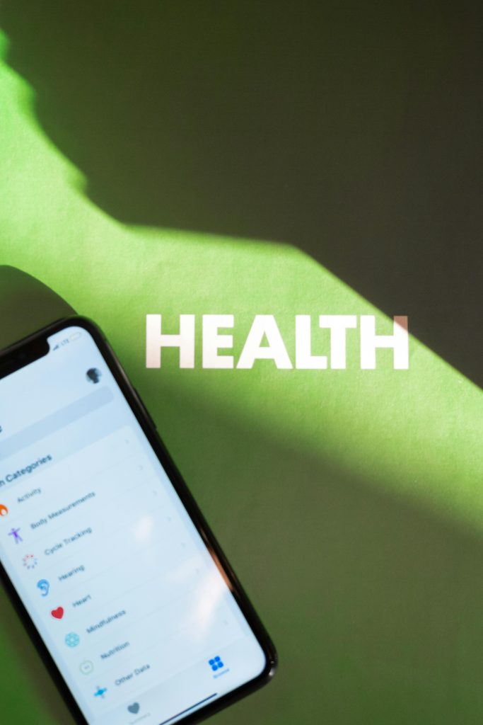 Smartphone affichant une application santé sous une lumière et une ombre sur un fond vert