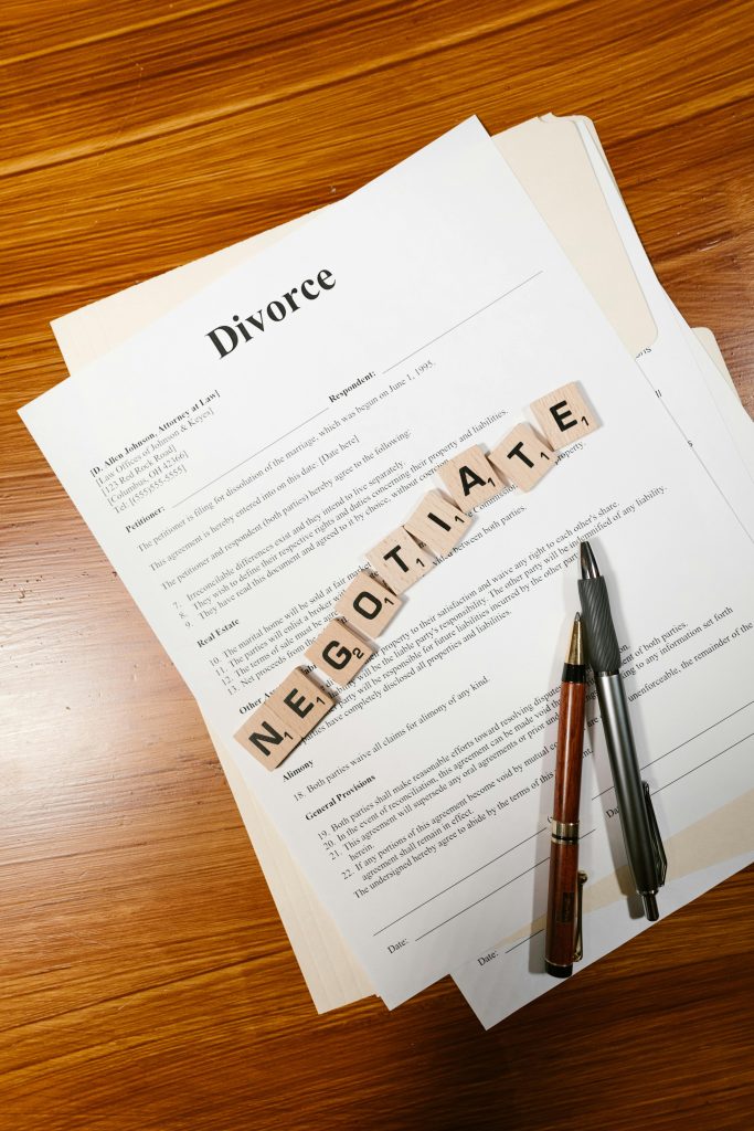 Divorce papers and 'negotiate' tiles symbolize mediation and legal discussions. Les documents de divorce et les tuiles « négocier » symbolisent la médiation et les discussions juridiques.
