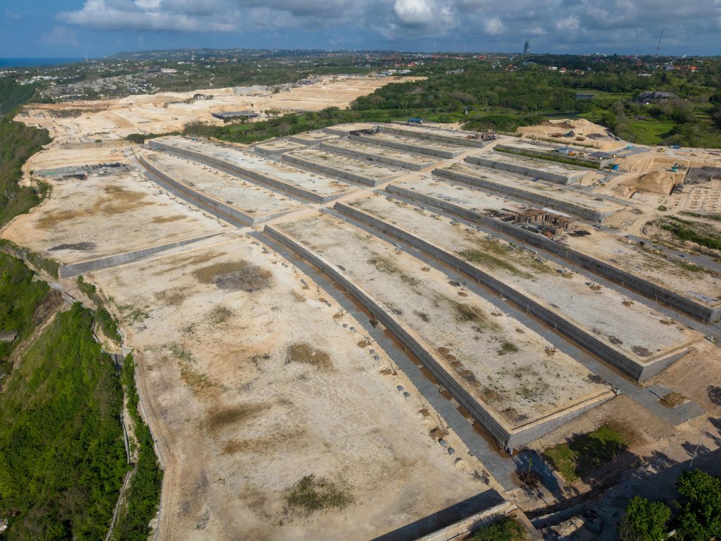 Expansive vue aérienne d'un grand chantier de construction à Bali, en Indonésie, sous un ciel nuageux.