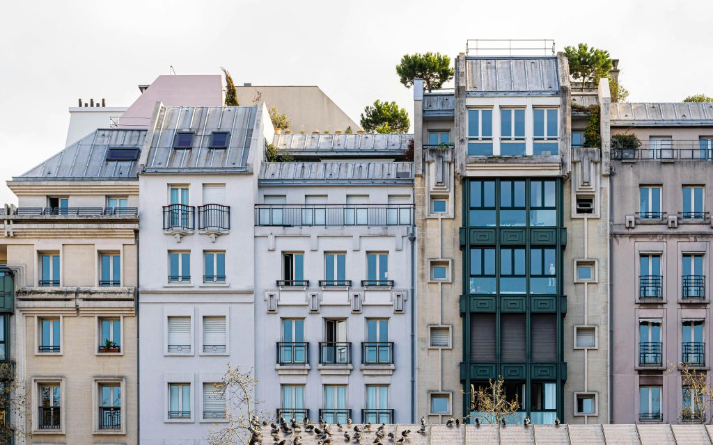 Un vue pittoresque d'une façade de bâtiment parisien classique avec balcons et fenêtres.