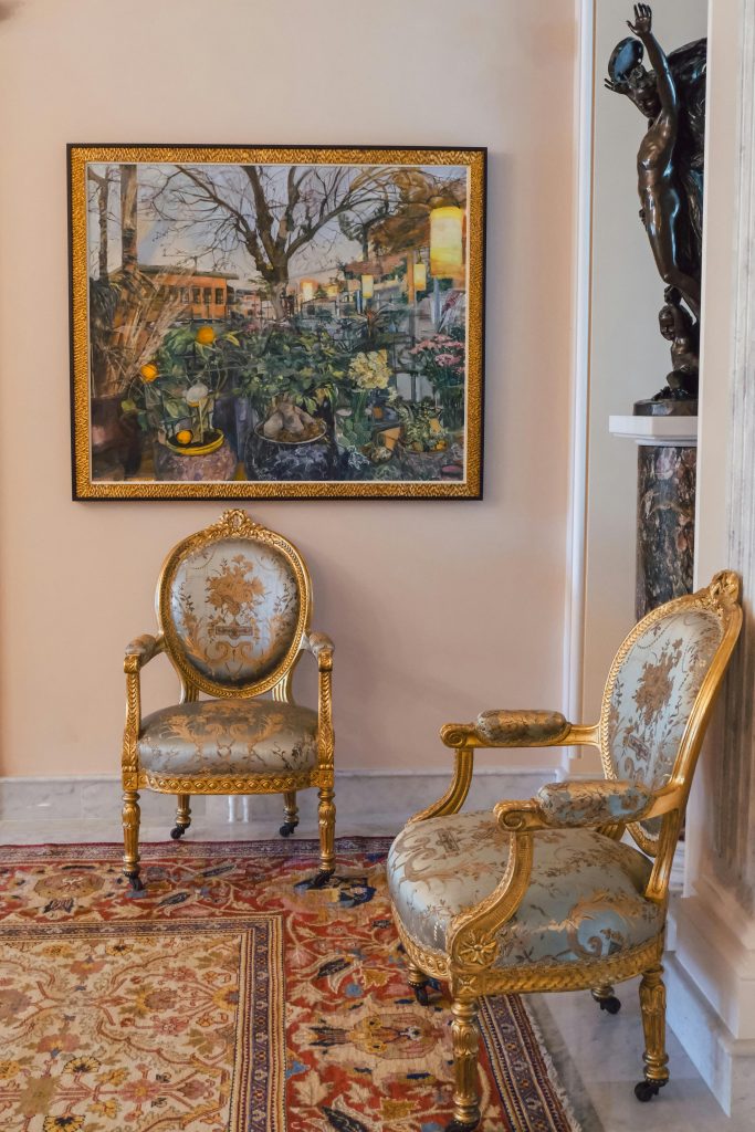 Two ornate vintage chairs in an opulent museum setting, showcasing classic luxury. Deux chaises vintage ornées dans un cadre de musée opulent, mettant en valeur le luxe classique.