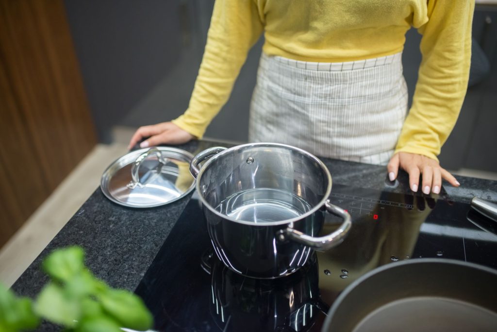 Femme qui cuisine sur une plaque à induction