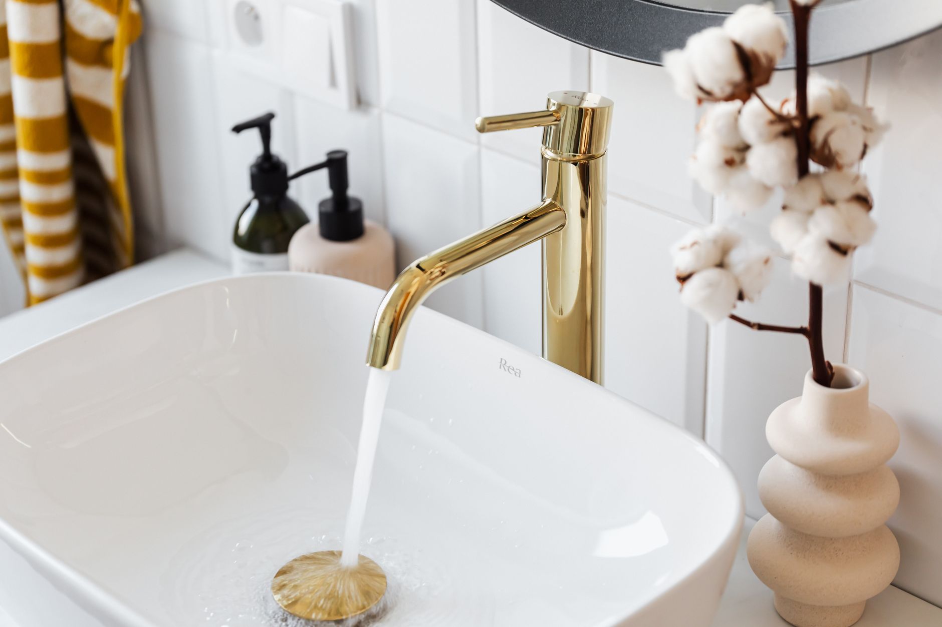 Robinet doré et évacuation dans une salle de bain moderne
