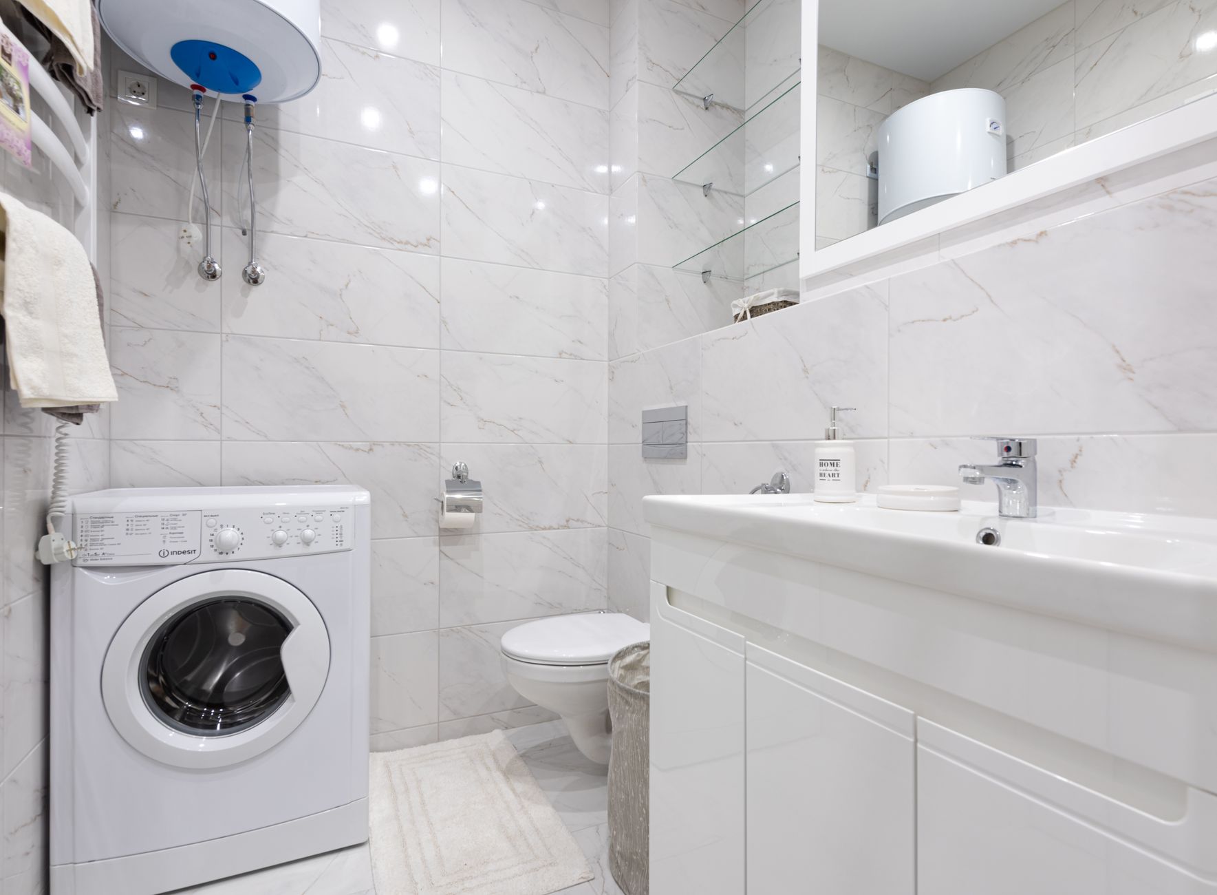 Salle de bain lumineuse avec lave-linge et équipements modernes