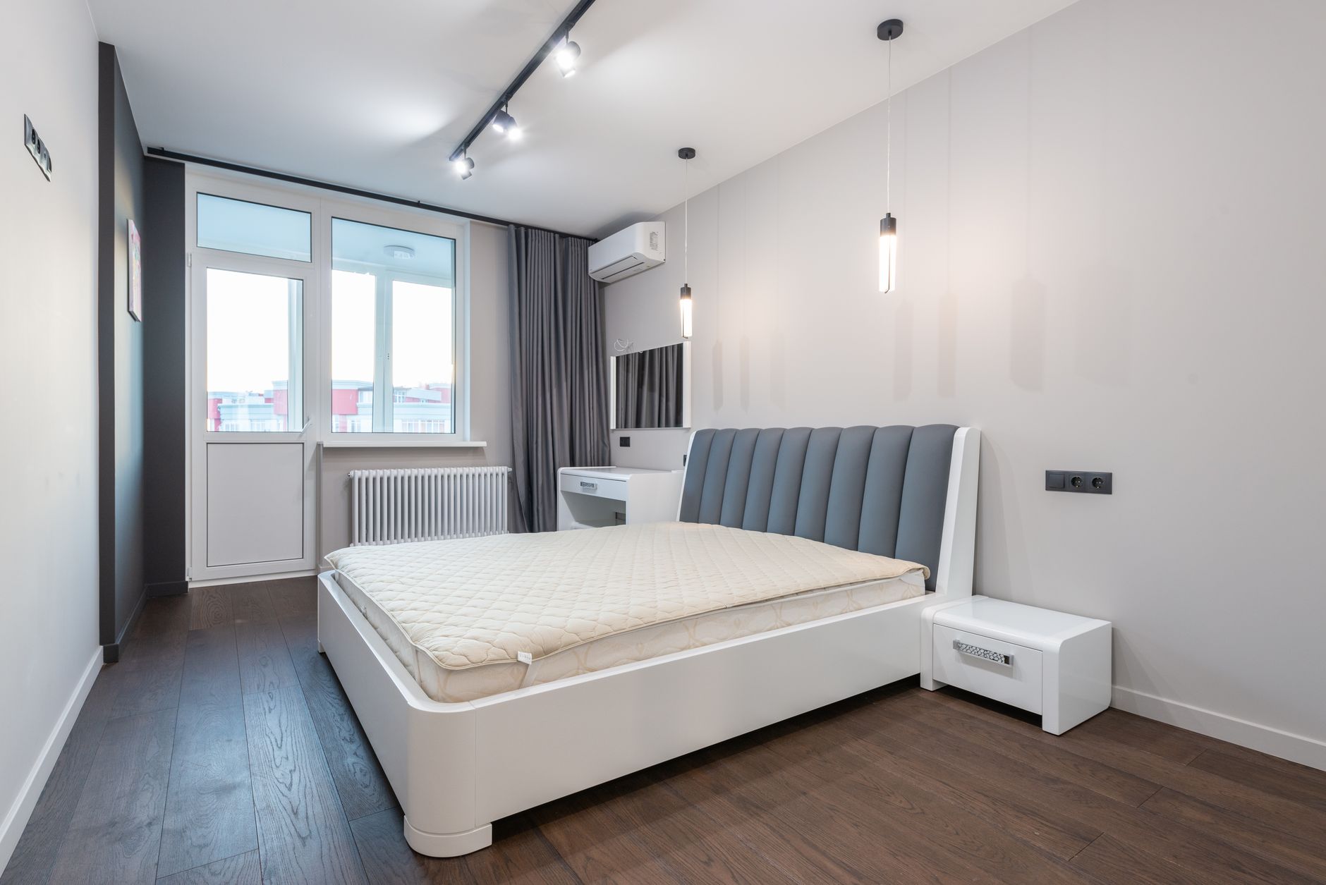 Chambre minimaliste avec parquet clair et murs blancs