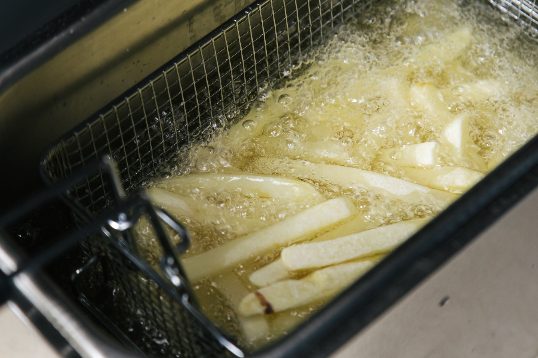Panier air fryer rempli de légumes coupés