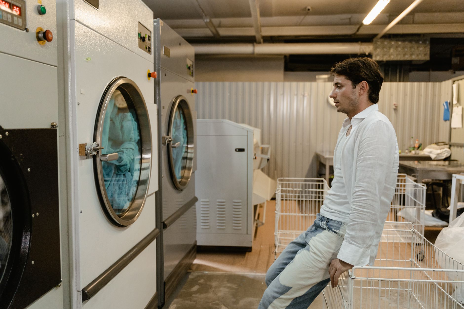 Homme qui attend devant les machines à laver