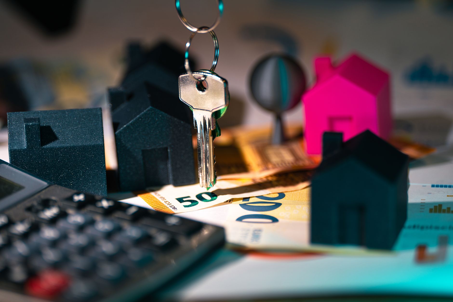 Clés, maquettes de maisons et billets sur une table
