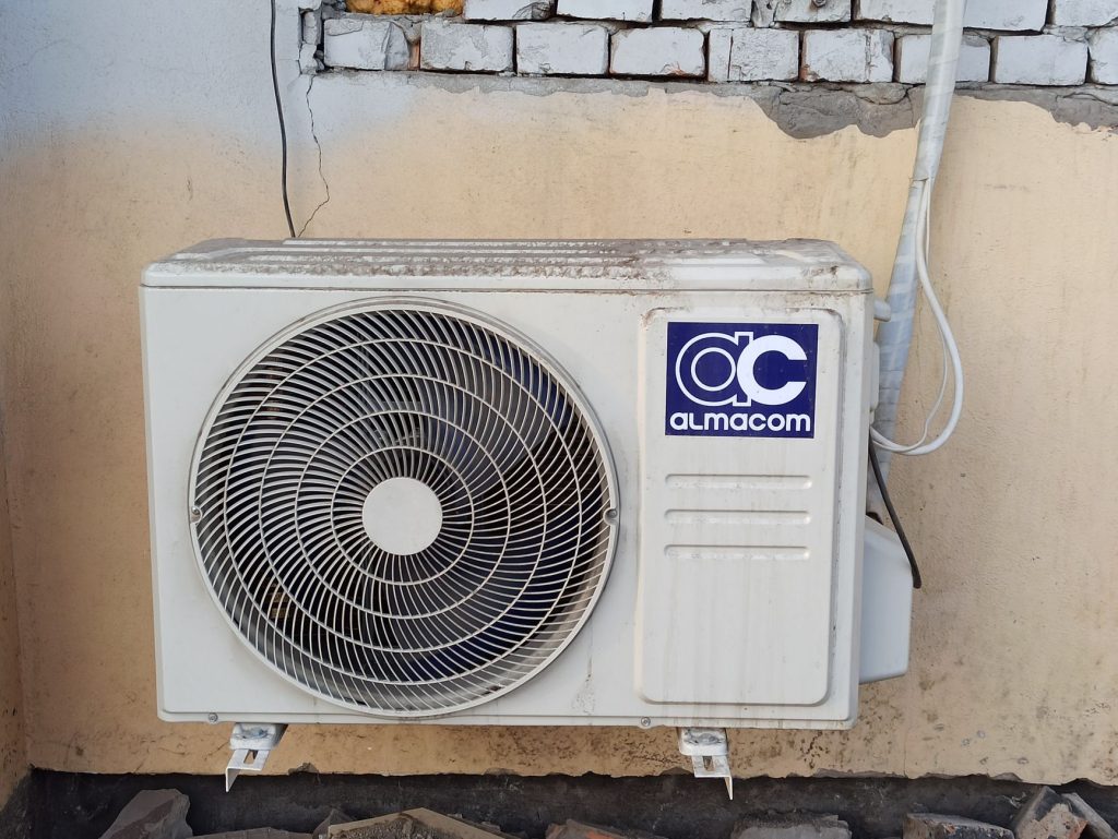 Unité extérieure de climatisation sur un mur de briques