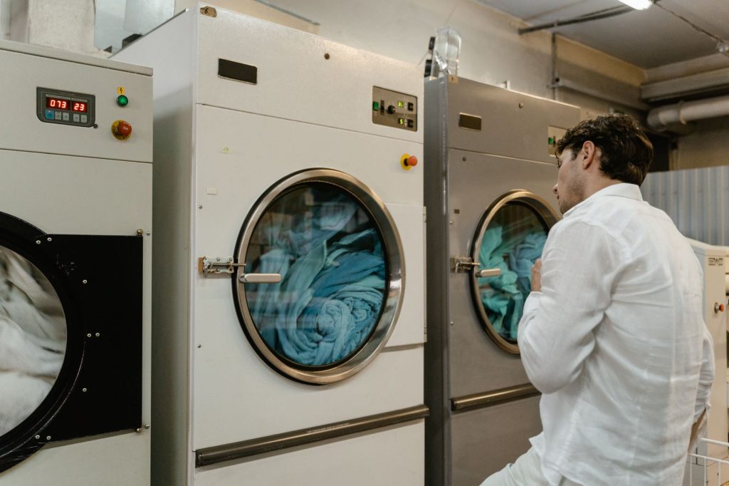 Utilisateur devant des machines à laver en laverie