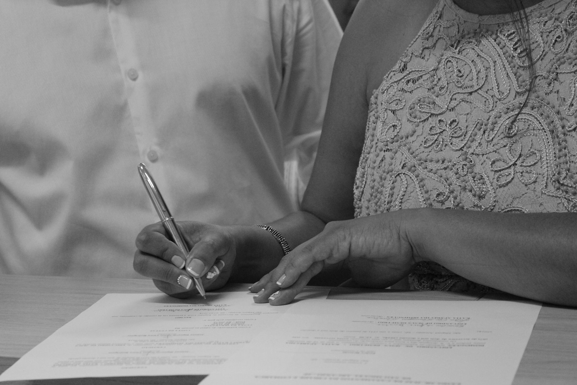 Couple en noir et blanc qui signe des documents
